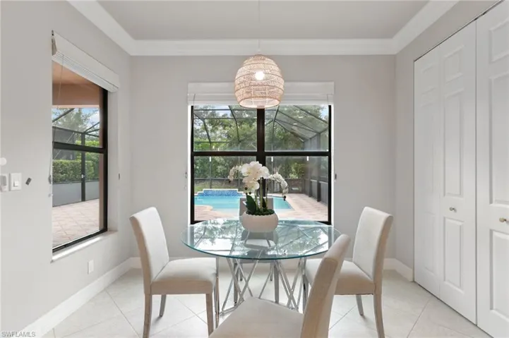 Tiled dining room with crown molding and a sunroom