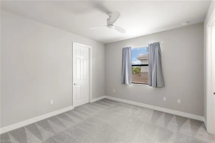 Unfurnished room with light carpet and a ceiling fan