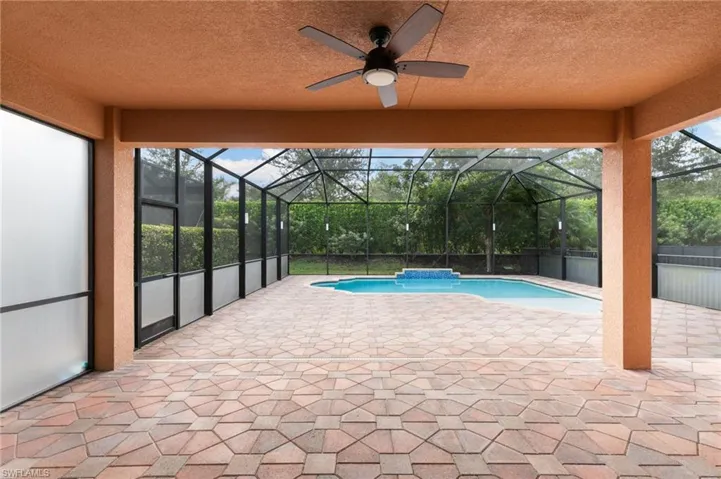 Outdoor pool with a patio, glass enclosure, a sunroom, and a ceiling fan