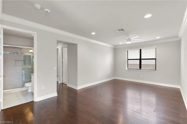 Spare room featuring ornamental molding, dark wood-type flooring, recessed lighting, and a ceiling fan