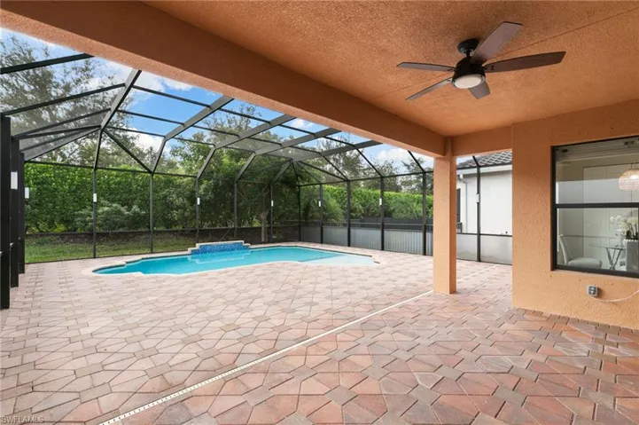 Outdoor pool featuring a patio area, glass enclosure, a sunroom, and ceiling fan