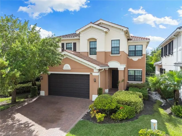 Mediterranean / spanish house featuring a tile roof, decorative driveway, stucco siding, and an attached garage
