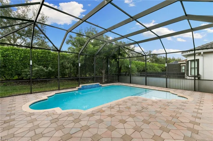 Swimming pool with a lanai, a sunroom, and a patio area