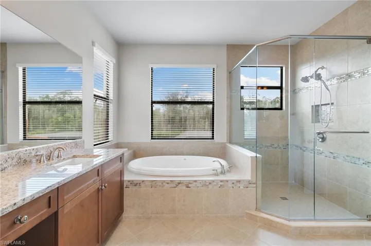 Bathroom with vanity, a stall shower, a bath, and light tile patterned flooring