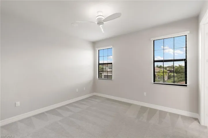 Unfurnished room featuring light colored carpet and ceiling fan