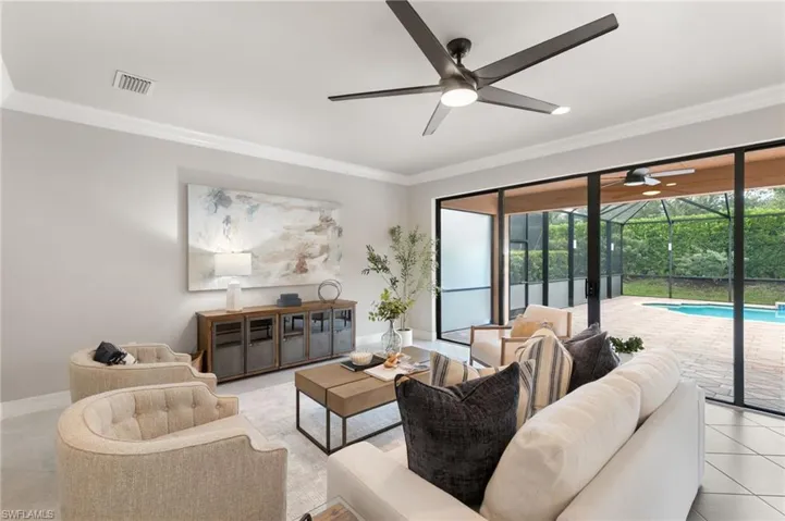 Living area featuring light tile patterned floors, ornamental molding, and a sunroom