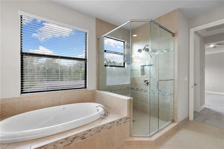 Bathroom featuring a stall shower, a garden tub, and tile patterned flooring