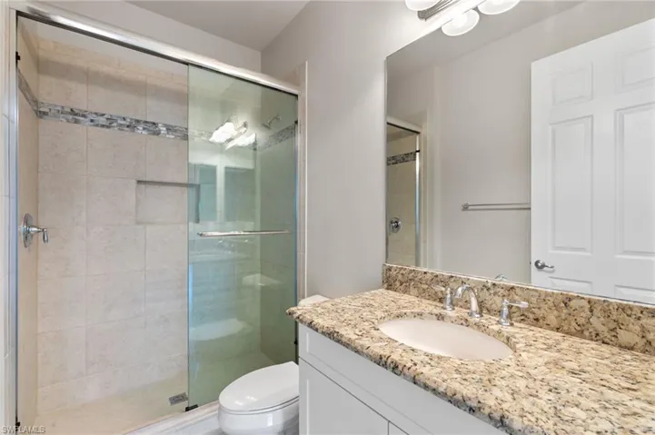 Full bathroom with vanity and a shower stall