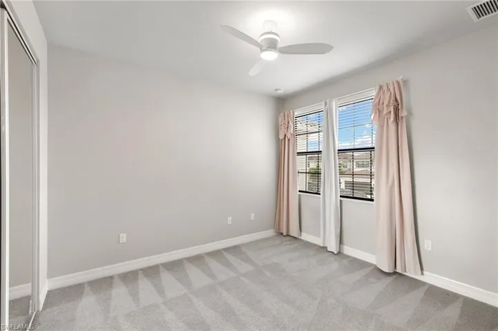 Empty room featuring light carpet and ceiling fan