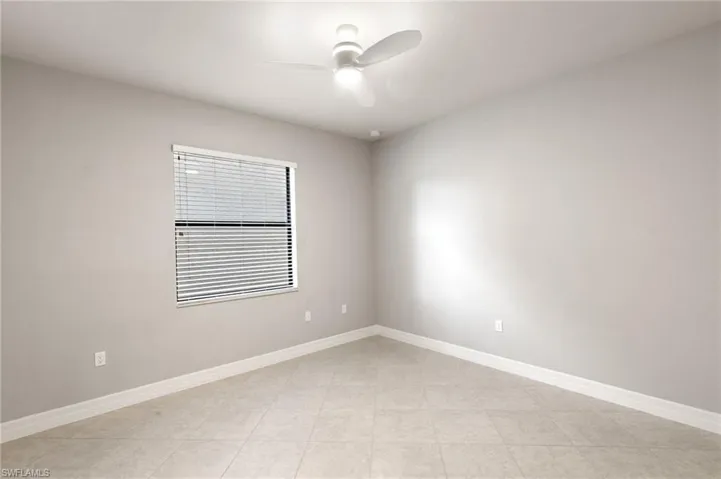 Unfurnished room with a ceiling fan and light tile patterned flooring