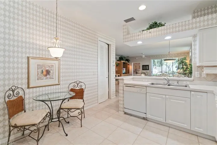Kitchen with hanging light fixtures, light countertops, dishwasher, white cabinets, and recessed lighting