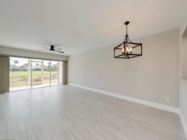 Empty room with ceiling fan with notable chandelier