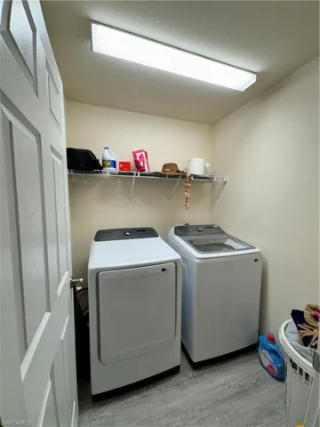 Washroom with laundry area, separate washer and dryer, and wood finished floors
