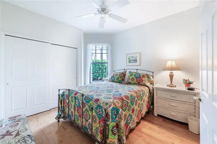 Guest Bedroom with wood finished floors, a closet, and a ceiling fan