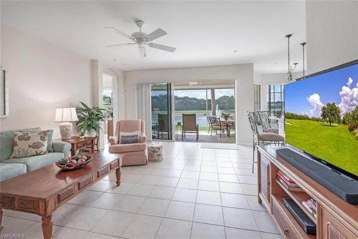 Living area with a ceiling fan and light tile patterned floors