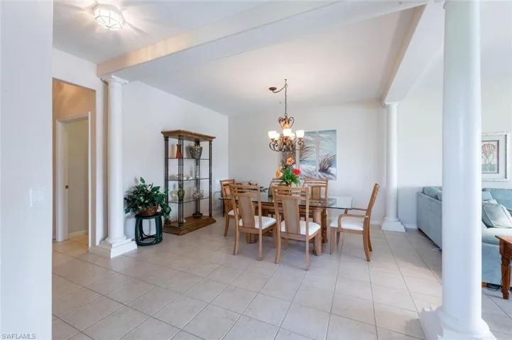 Dining area featuring decorative columns and light tile patterned floors