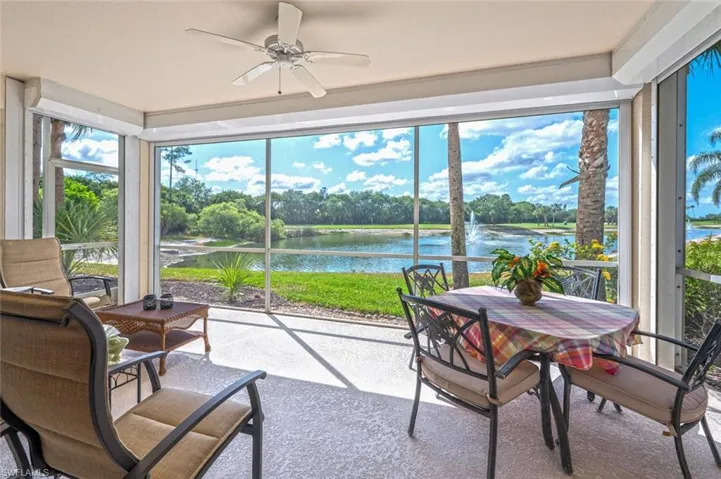 Sunroom with a water view, a ceiling fan, carpet flooring, and outdoor dining space