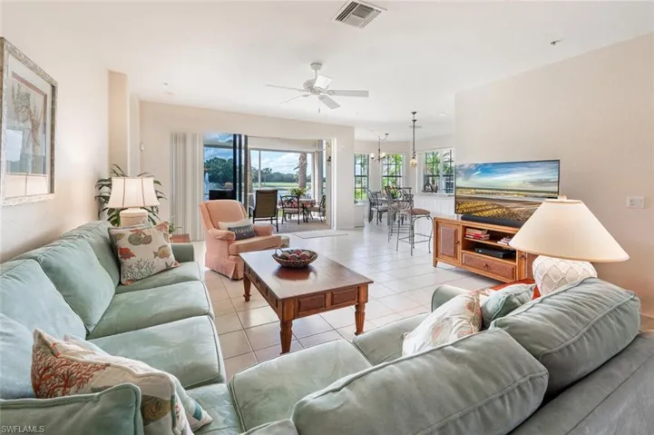 Living room with light tile patterned flooring and ceiling fan