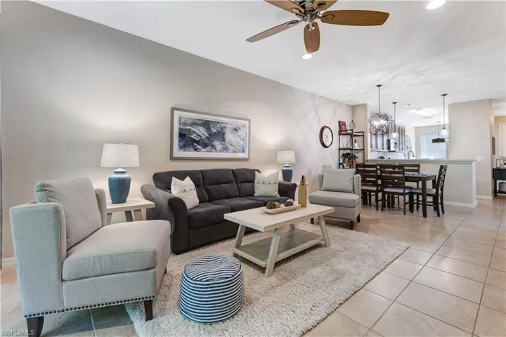 Expansive living area featuring a ceiling fan, tiled flooring, and a dining area with pendant lighting