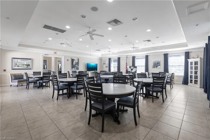 Spacious common area featuring tiled flooring, recessed lighting, ceiling fans, and windows with blinds and curtains