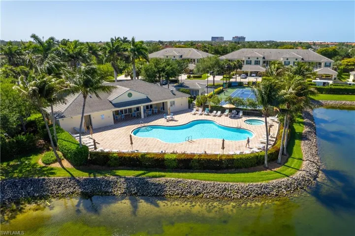 The property features a large outdoor pool with a paved deck, a spa, and a tennis court