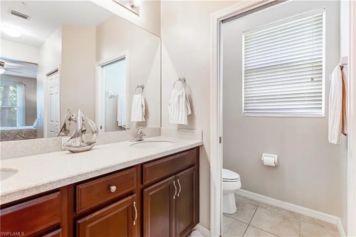 The bathroom features a dual sink vanity with dark wood cabinetry and a light-colored countertop