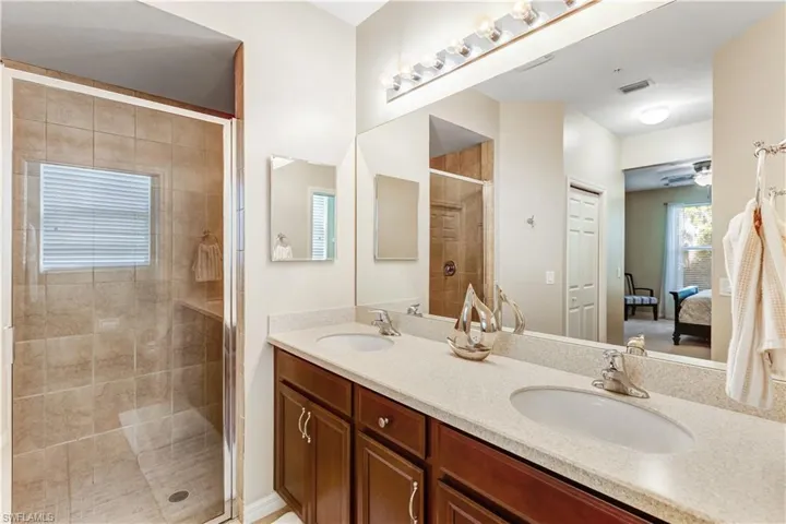 The bathroom features a dual sink vanity with a light-colored countertop and dark wood cabinetry