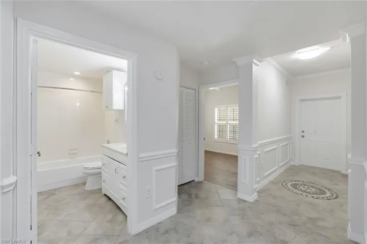 Hallway with crown molding and decorative columns