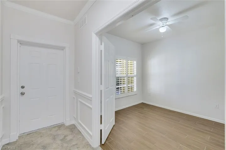 Entryway featuring crown molding, ceiling fan, and light hardwood / wood-style flooring