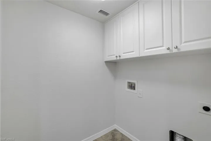 Clothes washing area featuring cabinets, hookup for a washing machine, and electric dryer hookup