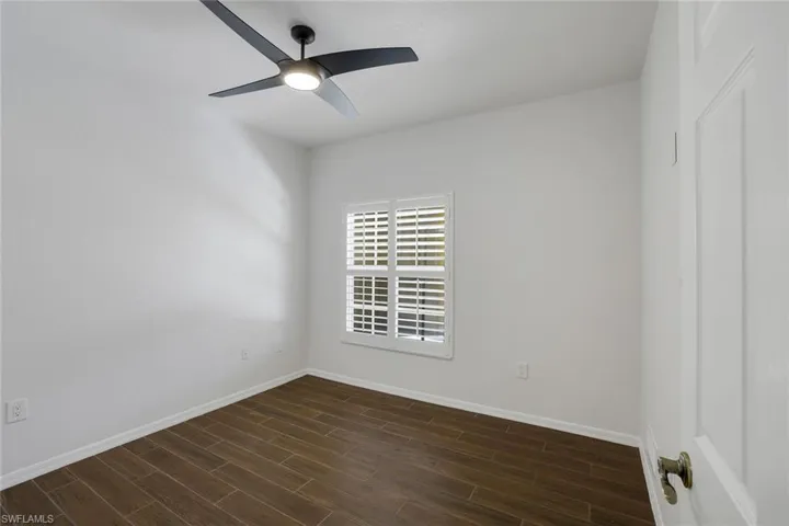Spare room featuring ceiling fan and dark hardwood / wood-style flooring