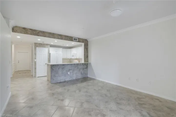 Unfurnished living room with crown molding