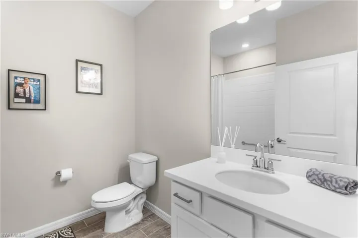 Bathroom featuring vanity, curtained shower, and wood tiled floors
