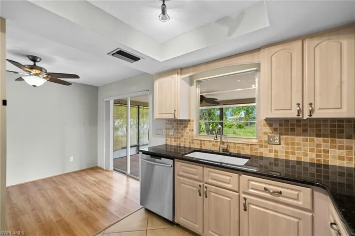 Kitchen featuring ceiling fan, light hardwood / wood-style floors, dishwasher, light brown cabinetry, and sink