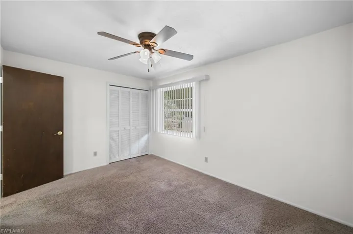 Empty room featuring carpet flooring and ceiling fan