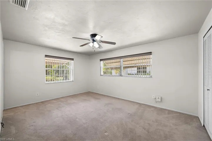 Carpeted empty room featuring ceiling fan