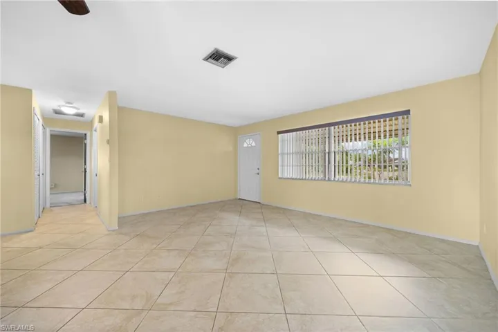 Unfurnished room with ceiling fan and light tile floors