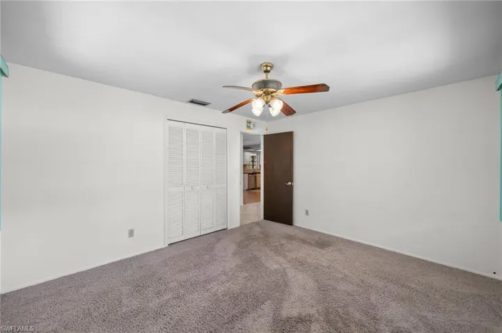 Unfurnished bedroom with carpet, ceiling fan, and a closet