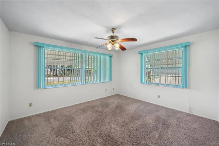Carpeted spare room featuring a wealth of natural light and ceiling fan