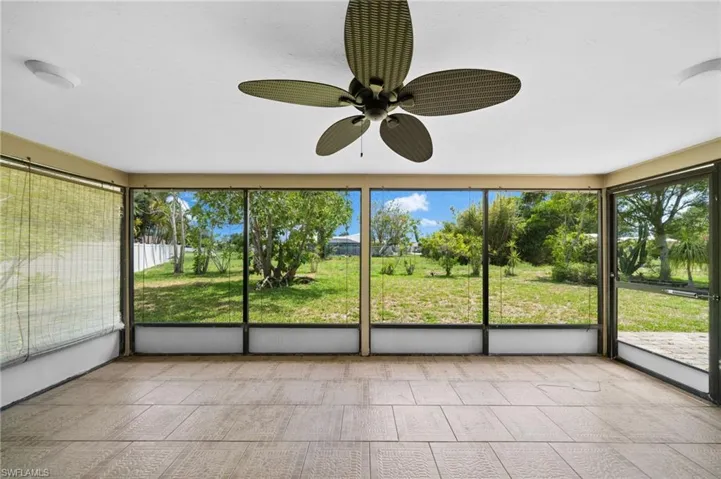 Unfurnished sunroom featuring ceiling fan