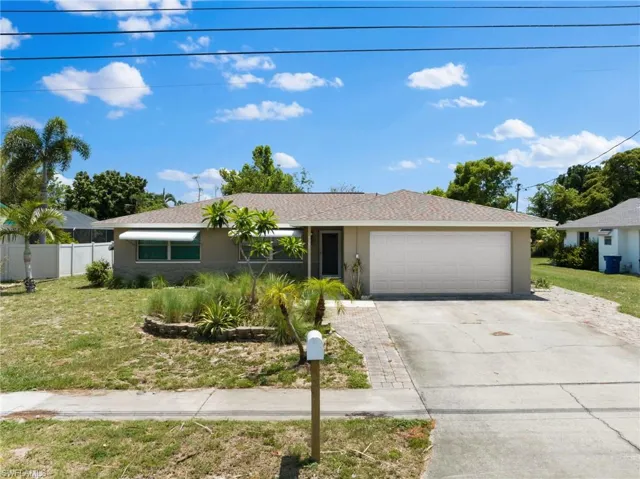 Single story home with a front yard and a garage