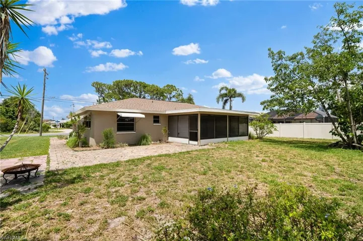 Rear view of property featuring a patio, a sunroom, and a yard