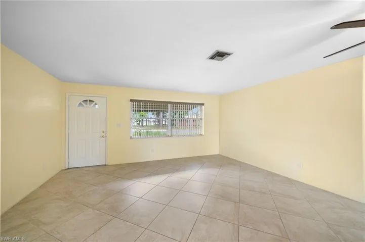 Unfurnished room featuring ceiling fan and light tile flooring