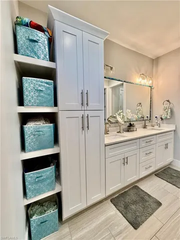 Bathroom featuring double vanity, a closet, and wood finish floors