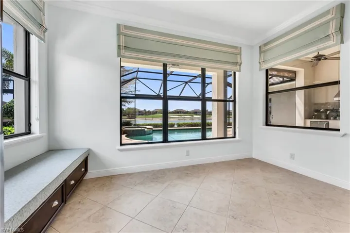 Unfurnished room featuring healthy amount of natural light, crown molding, a ceiling fan, a sunroom, and light tile patterned flooring