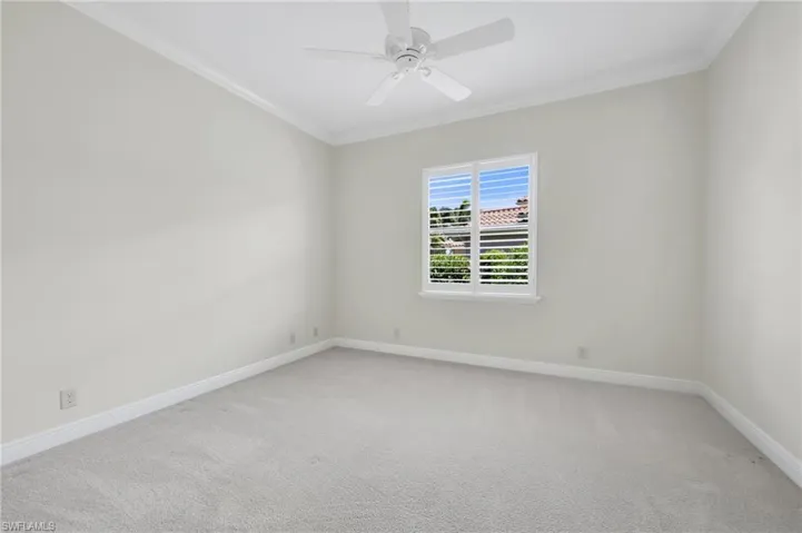 Spare room with crown molding, light carpet, and ceiling fan