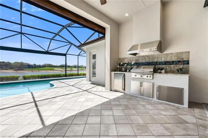 View of patio / terrace featuring a sunroom, an outdoor pool, glass enclosure, area for grilling, and a residential view