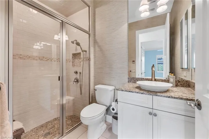 Full bath featuring vanity, a shower stall, and light tile patterned floors