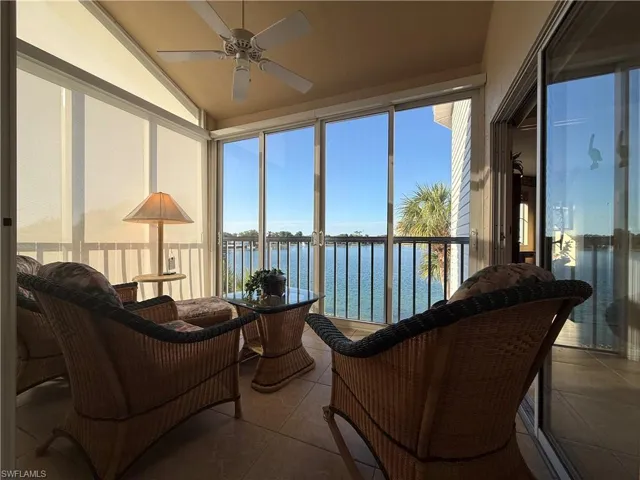 Sunroom featuring a water view, tile patterned flooring, plenty of natural light, and lofted ceiling