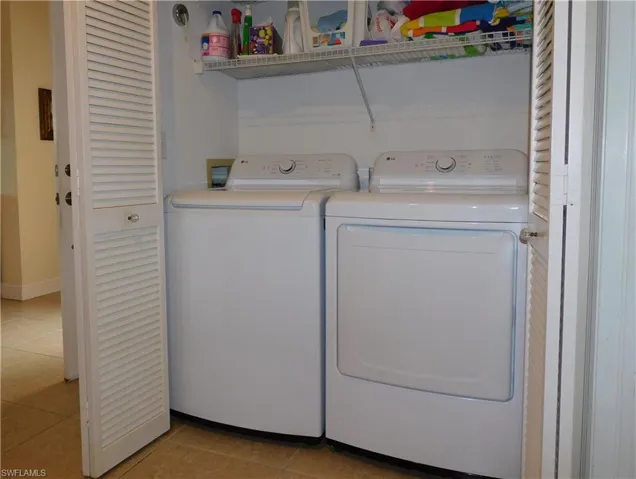 Laundry room featuring light tile patterned floors and washer and dryer